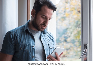 Sad Man Holding Phone Alone At Home