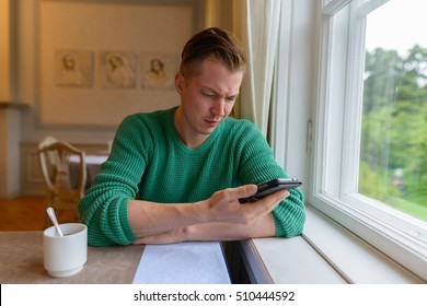 Sad Man Looking At His Mobile Phone