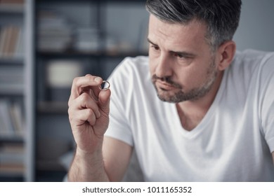 Sad Man Looking At His Wedding Ring After A Divorce Case