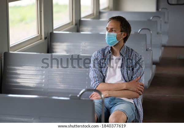 Sad\
man looking at window, wear face protective mask in train to\
protect the respiratory system from coronavirus infection,\
covid-19. Preventive measure. New normal concept.\
