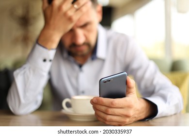 Sad Man With Phone In Cafe