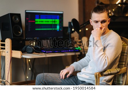 Sad man sitting in front of computer after unsuccessful and measuring work with different program with sound remix