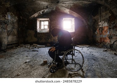 Sad man sitting in old wheelchair in abandoned hospital ward. Person silhouette in decayed vehicle for disabled patients in old building. - Powered by Shutterstock