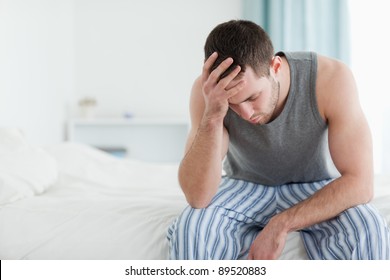 Sad Man Sitting On His Bed With His Head On His Hand