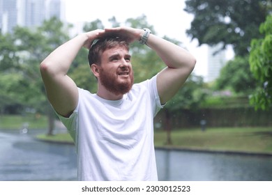 Sad man under summer rain.emotional guy wet in the rain without umbrella walk in the rain.young attractive male is wet in the rain - Powered by Shutterstock