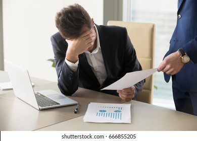 Sad manager getting notice of dismissal, sitting at workplace with laptop and financial documents, employee receiving letter with bad news, entrepreneur upset by commercial failure or firm bankruptcy  - Powered by Shutterstock