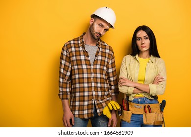 Sad Manual Workers With Crossed Arms On Yellow 