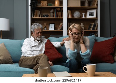 Sad mature woman sitting away from her husband after having quarrel. Senior couple not talking having argue at their home. Marriage crisis relationship problems. - Powered by Shutterstock