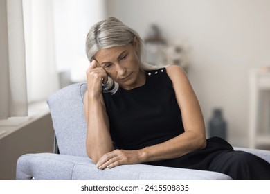 Sad melancholic mature woman sit alone at home deep in thoughts, thinking about personal life troubles, unrealized goals, marriage split feel unhappy and lonely. Middle age crisis, divorce, nostalgia - Powered by Shutterstock