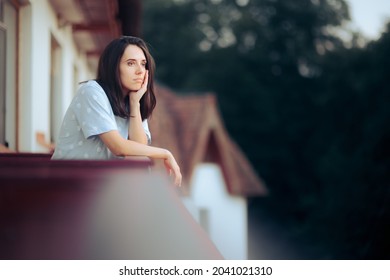 Sad Melancholic Woman Sitting in the Balcony. Unhappy lonely girl in self isolation from the world feeling nostalgic
				