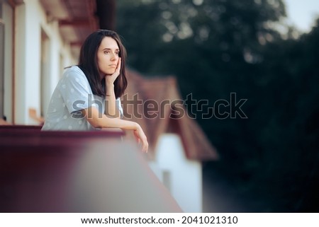 Sad Melancholic Woman Sitting in the Balcony. Unhappy lonely girl in self isolation from the world feeling nostalgic
