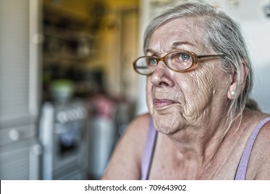 Sad Memories. Old Woman Sitting At A Table In His House, With A Worried Expression On His Face. Portrait Of Sad Lonely Pensive Old Senior Woman