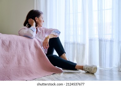 Sad Middle Aged Depressed Woman Sitting On The Floor In The Bedroom.