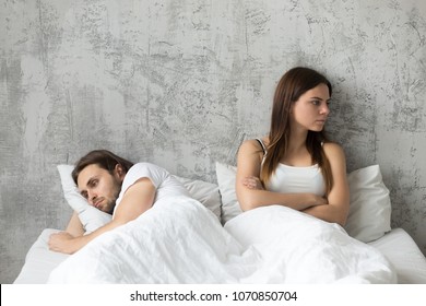 Sad millennial lovers after quarrel fight ignoring avoiding sex in bed, frustrated man and woman not talking feeling offended or stubborn, unhappy married couple and sexual problems concept