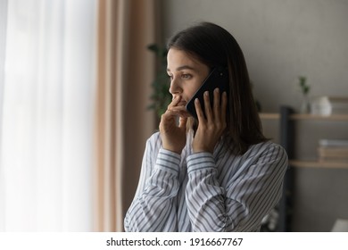 Sad millennial woman has difficult phone talk hold gadget by ear listen to unexpected bad news think on answer. Compassionate young lady support friend by cell try to help ponder on advice. Copy space - Shutterstock ID 1916667767