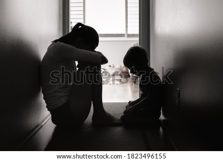 Sad mother and child sitting on the floor at home. 