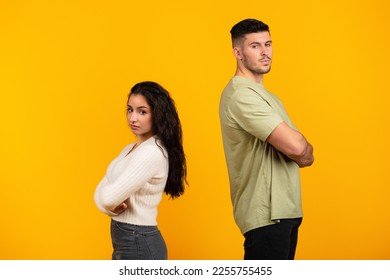 Sad offended young middle eastern woman ignores boyfriend in casual with crossed arms, think about divorce isolated on yellow background, studio. Relationship problems, quarrel, emotions and breakup - Shutterstock ID 2255755455
