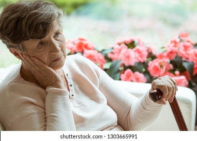 Sad Old Lady With Cane Sitting Alone At Nursing Home Waiting For Her Grandchildren