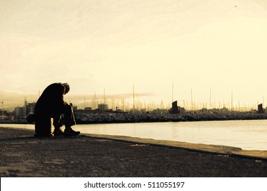 Sad old man sitting by the sea. Concept about people, sadness and loneliness
