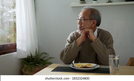 Sad Old Retired Gray Haired Grandpa Asian Man Sitting Alone At Table Desk At Window Boring Stay Home Self Isolation Quarantine Feeling Depress In Problem Mental Health.