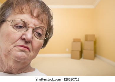 Sad Older Woman In Empty Room With Boxes - Concept For Foreclosure, Divorce, Moving, Etc.