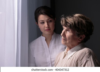 Sad Older Woman In Nursing Home Waiting For Relatives