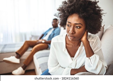 Sad pensive young girl thinking of relationships problems sitting on sofa with offended boyfriend, conflicts in marriage, upset couple after fight dispute, making decision of breaking up get divorced - Shutterstock ID 1824116360