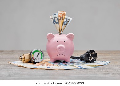 Sad piggybank for high cost of gas, electricity and power. Inflation is increasing everywhere, especially for gas and electricity bills. Saving and spending money due to power crisis.