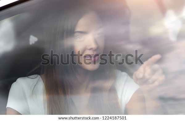 sad portrait of\
a woman outside a car\
window