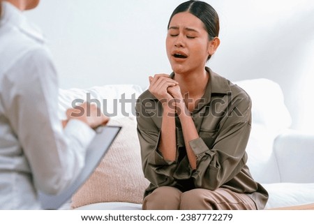 Sad PTSD woman patient in uttermost therapy for mental health with psychologist, depression or grief after life failure. Frustrated trauma young woman talking to a psychologist about emotion in office