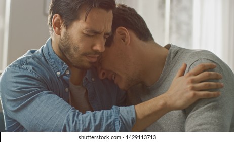 Sad Queer Drama Concept. Boyfriend is Unhappy and Depressed About Something. His Gay Friend is Comforting Him, Holding His Hands. Miserable Man Puts His Head on a Shoulder and Cries.