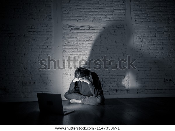 Sad and scared female Young woman with computer\
laptop suffering cyberbullying and harassment being online abused\
by stalker or gossip feeling desperate and humiliated in cyber\
bullying concept.