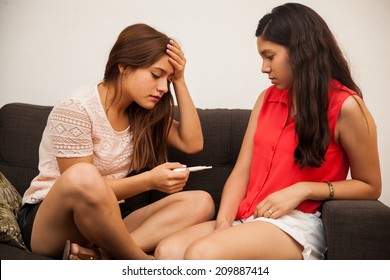 Sad And Scared Teen Holding A Pregnancy Test And Giving The News To Her Best Friend