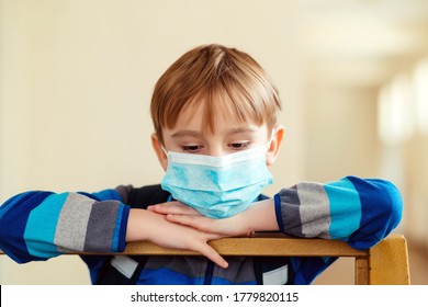 Sad Schoolboy With Medical Mask And Backpack Indoor. New Real Life 2020. Back To School During World Pandemic. Coronavirus Quarantine. Sad Child In School Class. Face Mask To Protect Covid-19.