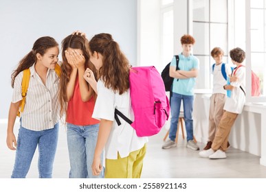 Sad schoolgirl crying as she is bullied by other children in school. Stress and emotional abuse caused by bullying, focusing on the negative impact on teens or kids and the need for support. - Powered by Shutterstock