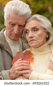 Sad Senior Couple Hugging Outdoors