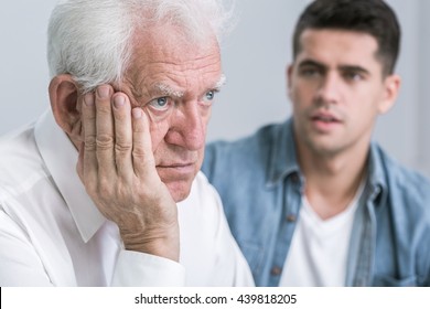 Sad senior man and his young caring son