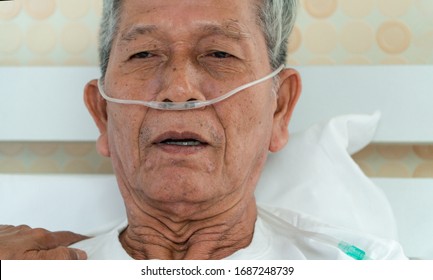 Sad Senior Man Lying On The Hospital Bed And With A Nasal Breathing Tube For Treatment Respiratory. Concept Of Health Care For The Elderly, Quarantine Coronavirus (COVID-19)