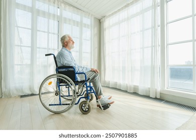 Sad senior man sitting in wheelchair looking out window in retirement home hospital. Old paralyzed man in chair for people with disability feel depressed. Lonely elderly sick man sitting on wheelchair - Powered by Shutterstock