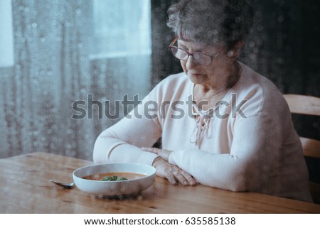 Sad, senior woman having lack of appetite