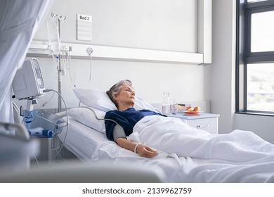 Sad senior woman lying on hospital bed and looking away. Depressed old woman lying thoughtful in hospital ward while looking through the window. Hospitalized elderly lady recovering from illness. - Powered by Shutterstock