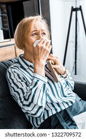 Sad Senior Woman Wiping Face From Tears With Tissue And Crying While Holding Picture Frame