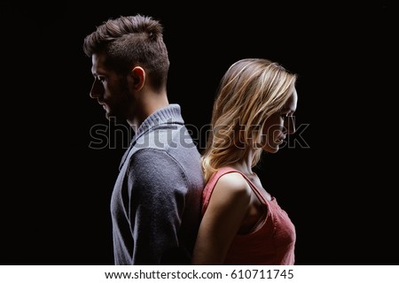 Sad serious couple standing back to back