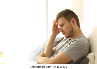 Sad Single Man Lamenting Sitting On The Bed On The Bed Of An Hotel Room Or Home