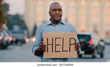 Sad Stressed Frustrated Elderly African American Poor Man Retirement Age, Lost Tourist, Holding Cardboard Banner With Inscription Need Help Asks For Money Crisis Health Problems During Covid Pandemic