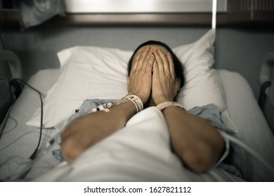 Sad Stressed Medical Patient Lying Down In Hospital Bed. 