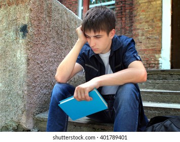 Sad Student With The Book On The Old House Background