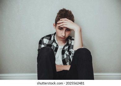 Sad teen boy sit on the floor thinking of her trouble and unhappy life and close his ears to resolve from your problems. Depression and anxiety disorder concept
