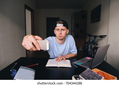 A Sad Teen Does Sedly While Studying At Home At The Desk In The Room. Selfies Fees