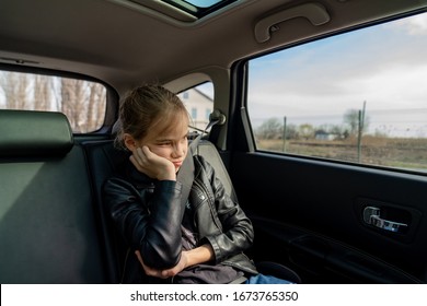 Sad Teen Girl In A Black Leather Jacket Rejoices Looks Out The Window In The Back Seat Of The Car